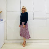 Relaxed fit, black bamboo, v neckline, long sleeve, tie front detail, dressy top. Worn with midi length skirt with slight hemline ruffle in black,white and pink. 