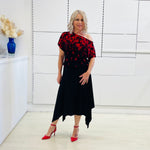 Black & red floral print, off the shoulder, asymmetrical neckline, relaxed fit top, worn with black, handkerchief hemline skirt with elastic waistband.