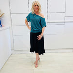 Stunning off the shoulder emerald green top with delicate shimmer. Flattering relaxed fit cut with stretch waistband for style and fit. Worn with black stretch skirt with asymmetrical hemline small ruffle detail.