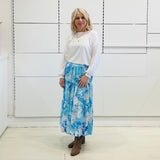 Relaxed, loose line fit, white bamboo, long sleeve with cuff and waistband shape, round neckline top. With blue skirt 