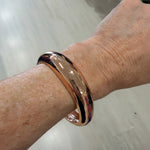 Gold bracelet on a wrist with a blurred background
