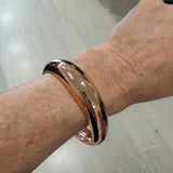 Gold bracelet on a wrist with a blurred background