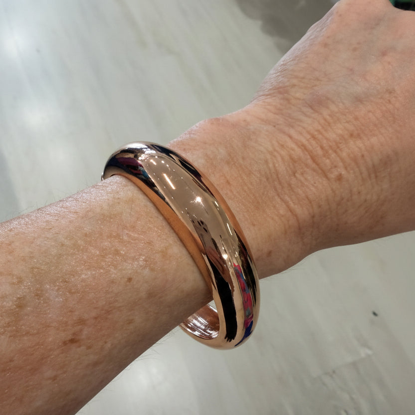 Gold bracelet on a wrist with a blurred background