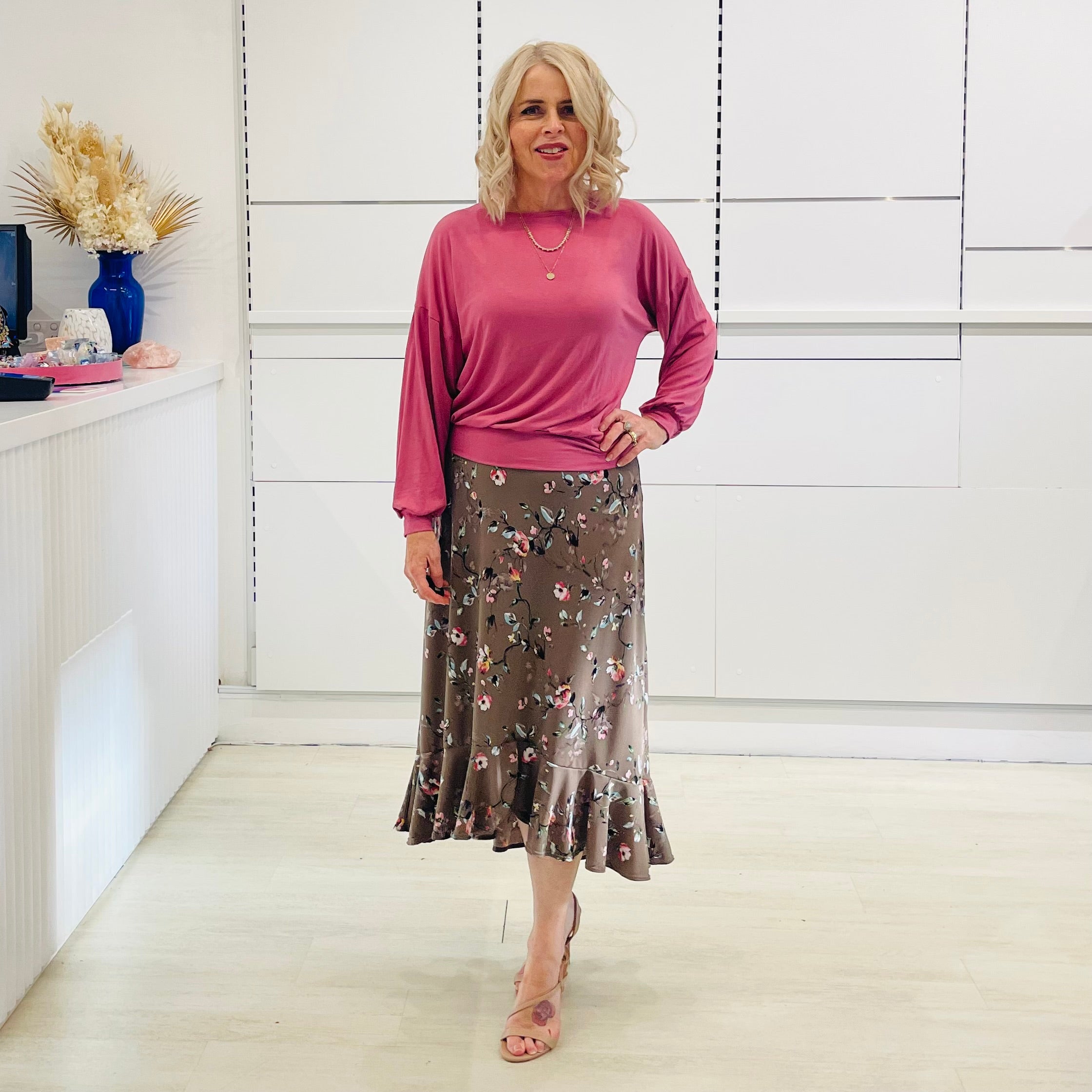 Relaxed, loose line fit top, long sleeve,with wrist cuff, round neck, waistband for shape. With soft drape midi length, brown floral skirt with soft ruffle on asymmetrical hemline.
