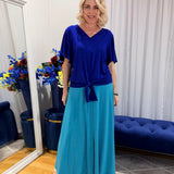 Woman wearing blue top and green skirt 