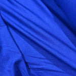 A close-up of draped royal blue fabric with soft folds and a smooth texture.