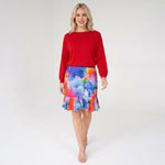 Woman wearing a red top and colorful skirt on a white background