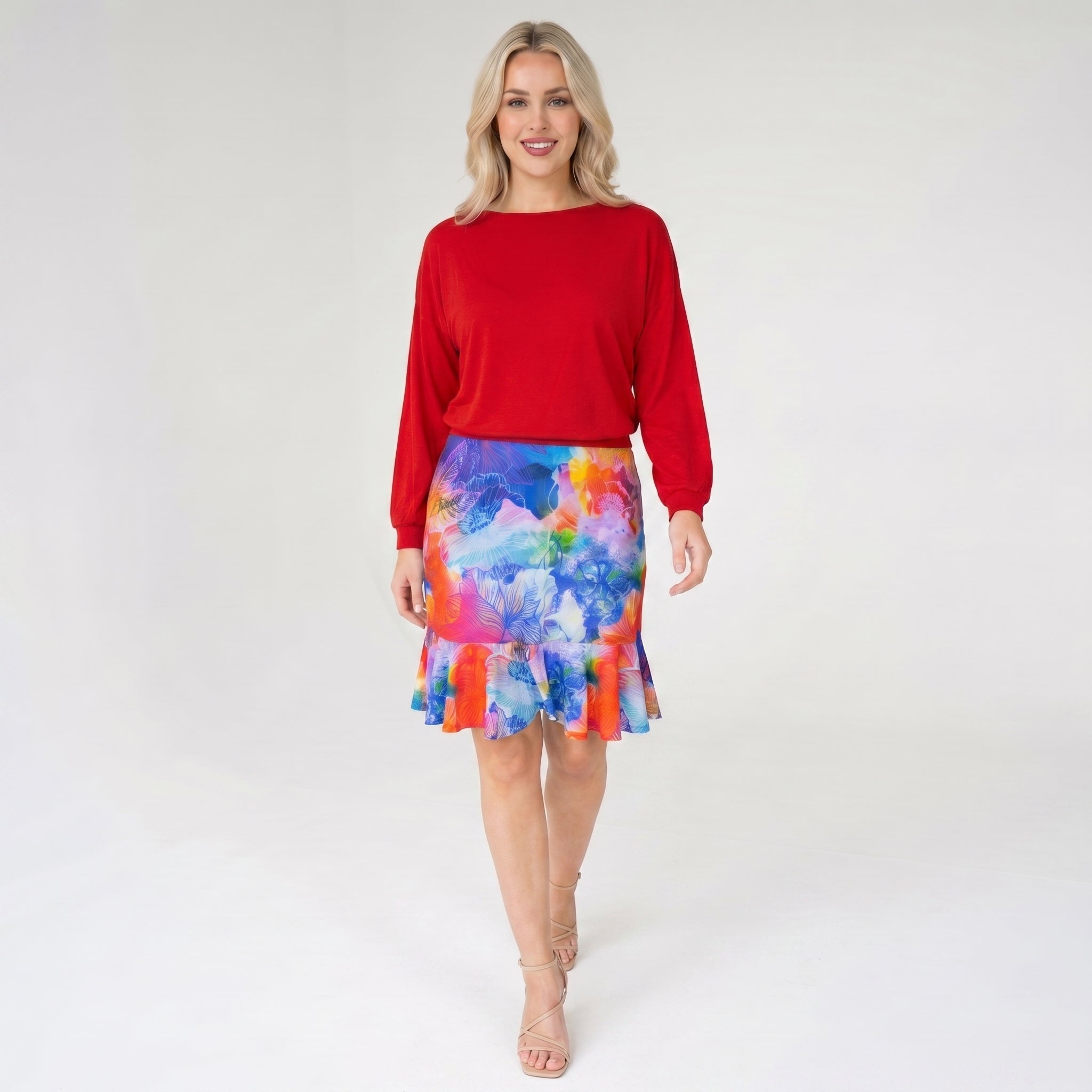 Woman wearing a red top and colorful skirt on a white background