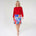 Woman wearing a red top and colorful skirt on a white background