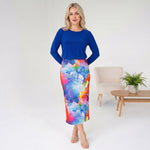 Woman wearing a blue top and colorful skirt in a minimalistic room.