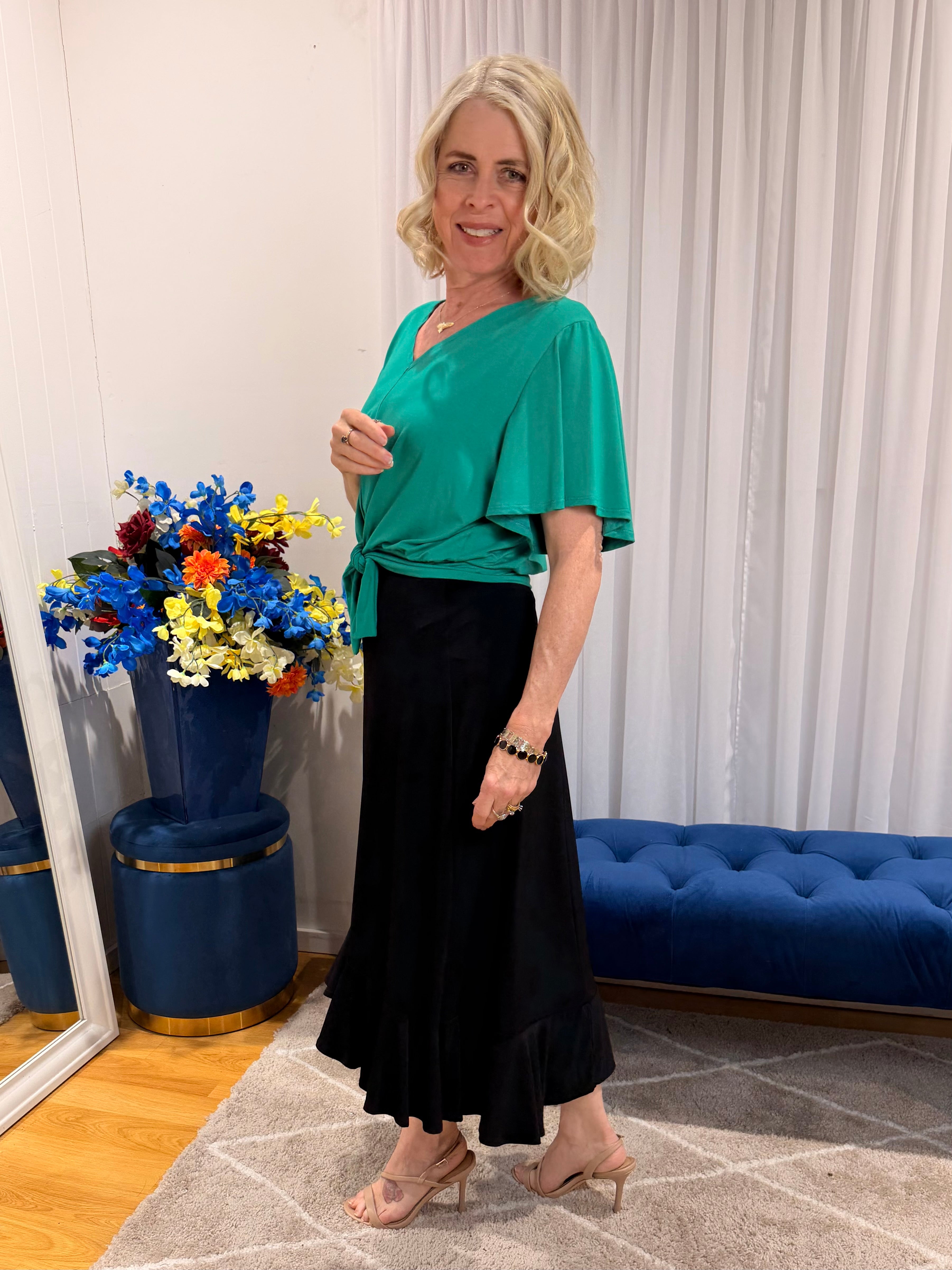 Woman wearing green top and black skirt
