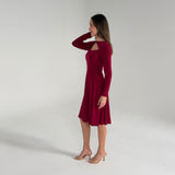Woman wearing a burgundy dress with long sleeves on a white background
