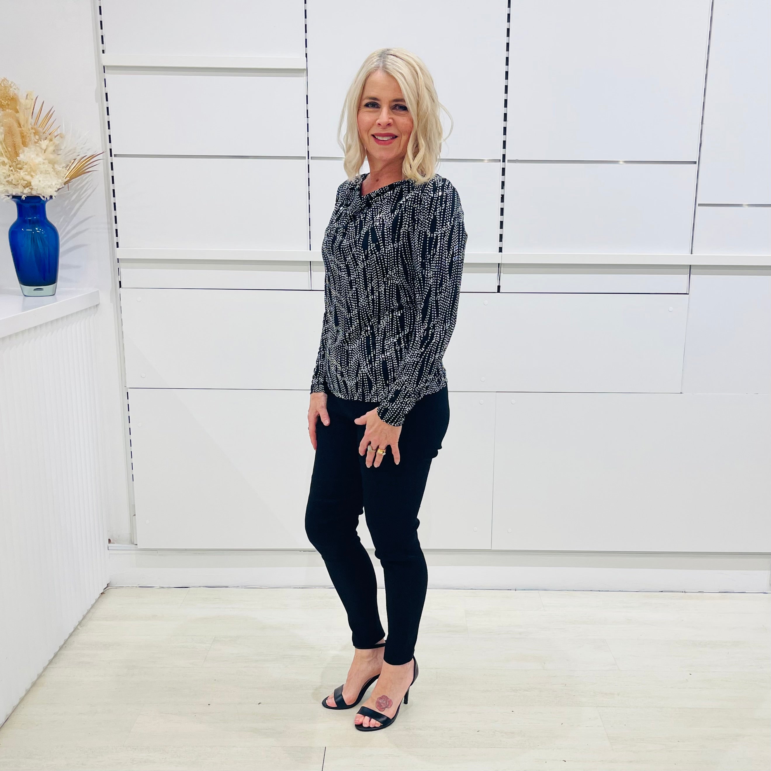 Black,white, and silver dot cowl neckline, long sleeve semi fitted top, with black fitted pants/trousers with pockets 