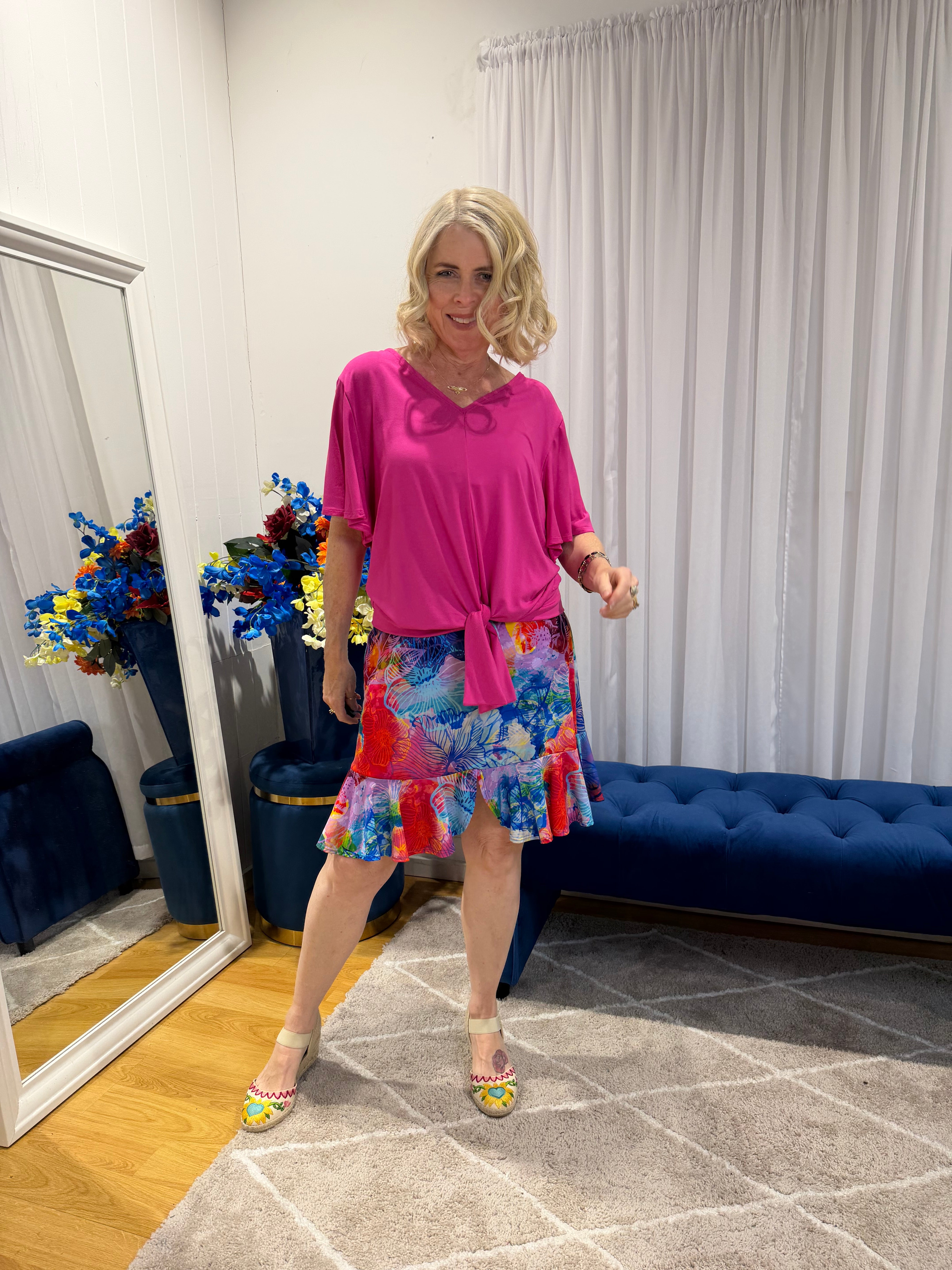 Woman wearing pink top and short colourful skirt 