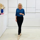 Stylish v- neck, three quarter sleeve blouse in a vibrant blue and black leopard print, paired with high-waisted black pants. A chic and polished look perfect for work or a smart casual outing