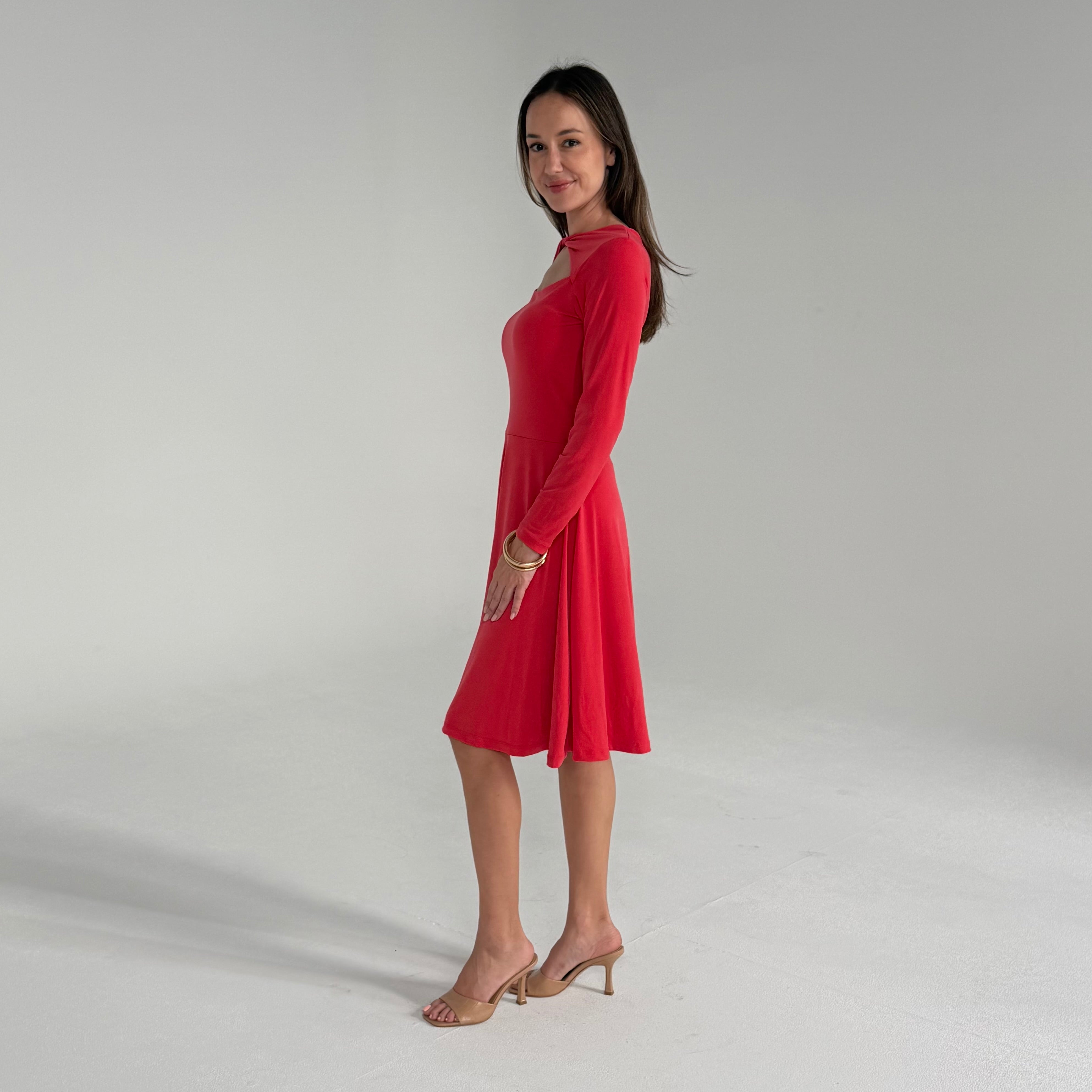 Woman wearing an orange dress on a plain background
