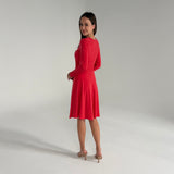 Woman wearing an orange dress on a plain background