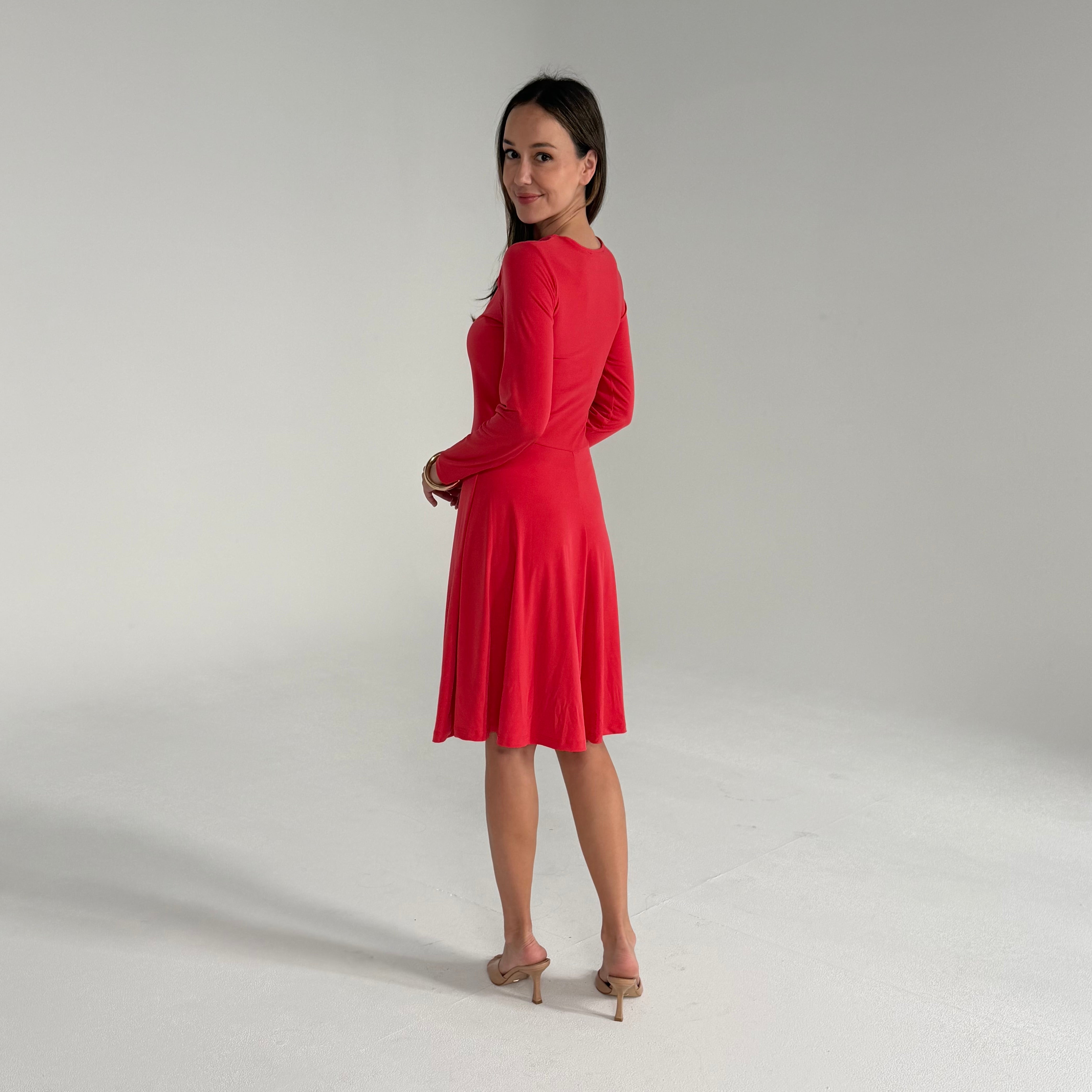 Woman wearing an orange dress on a plain background
