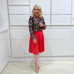 Bright watermelon pink Penelope dress on model- vibrant colour, stretch dress, with feminine silhouette, long sleeve, a-line skirt and keyhole neckline. Worn with Selena Embroidered silk bolero Jacket.