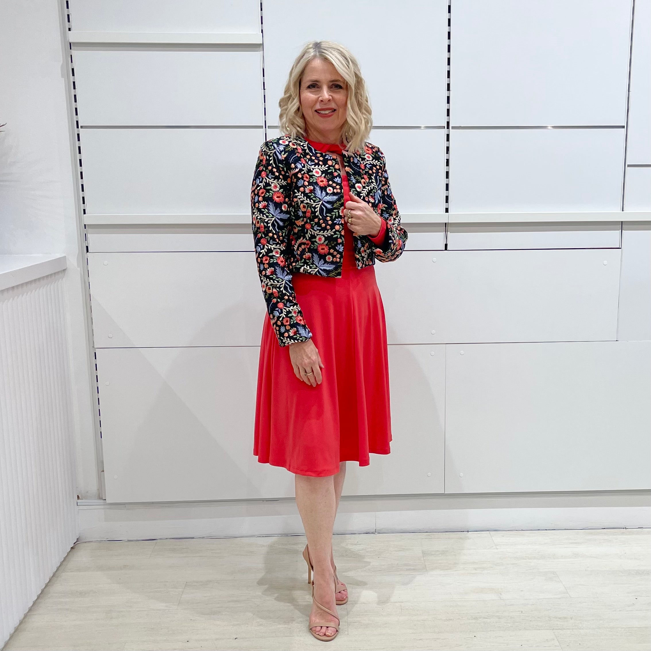 Bright watermelon pink Penelope dress on model- vibrant colour, stretch dress, with feminine silhouette, long sleeve, a-line skirt and keyhole neckline. Worn with Selena Embroidered silk bolero Jacket.
