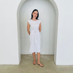 Woman in a white dress standing in a white archway