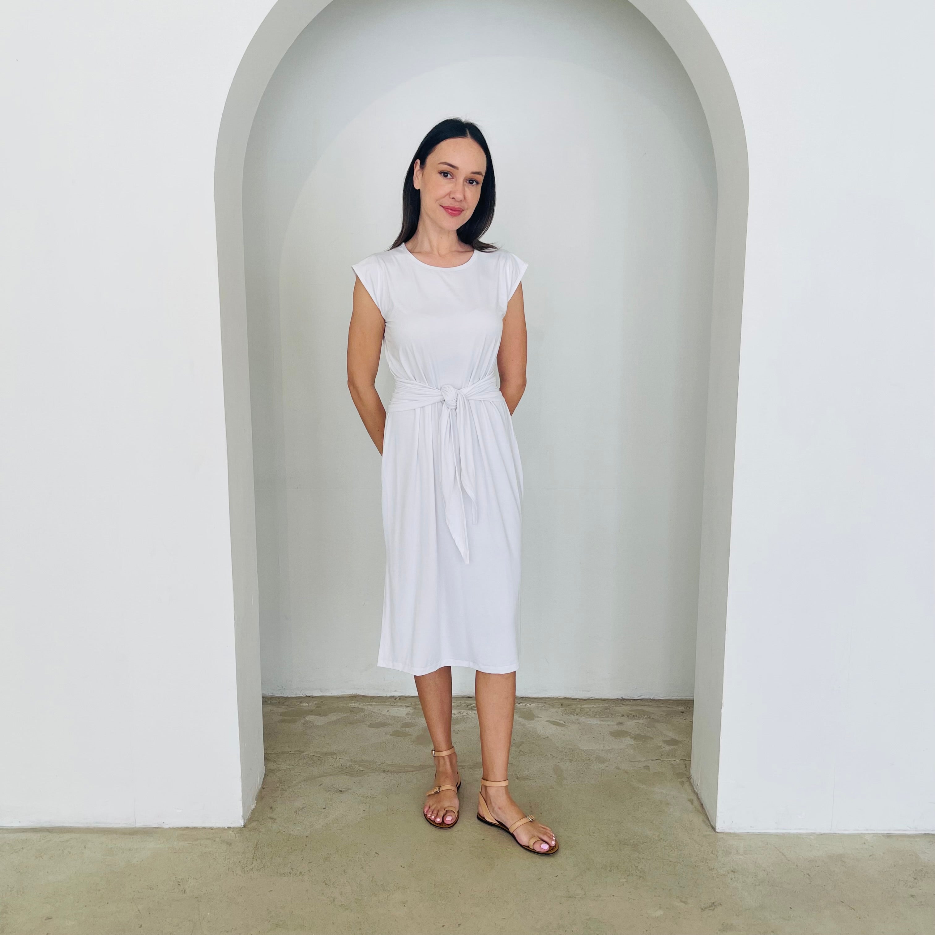 Woman in a white dress standing in a white archway