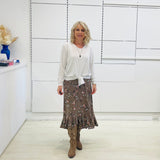 White long sleeve, v neckline, top with waist tie front, worn with floral, midi length skirt.