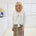 White long sleeve, v neckline, top with waist tie front, worn with floral, midi length skirt.