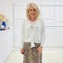 White long sleeve, v neckline, top with waist tie front, worn with floral, midi length skirt.