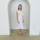Woman in a white dress standing in a white archway