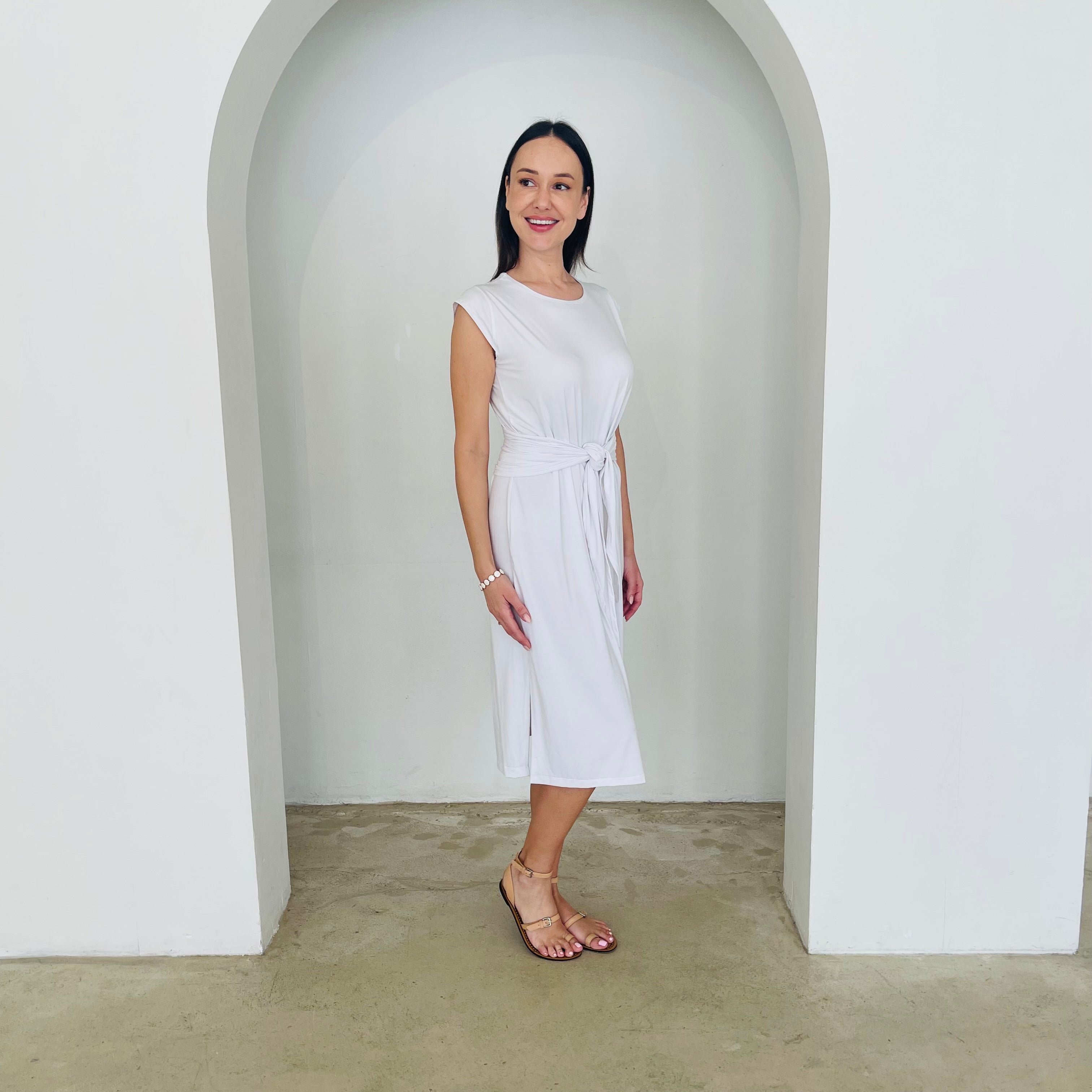 Woman in a white dress standing in a white archway