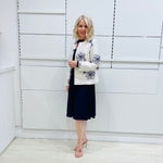 Penelope dress in deep navy blue, worn by model- elegant long sleeve design, knee length, with modern neckline, worn with  Ivory & navy embroidered silk jacket, designed and Made in Australia.