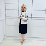 Penelope dress in deep navy blue, worn by model- elegant long sleeve design, knee length, with modern neckline, worn with  Ivory & navy embroidered silk jacket, designed and Made in Australia.