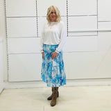 Relaxed, loose line fit, white bamboo, long sleeve with cuff and waistband shape, round neckline top. With blue skirt 