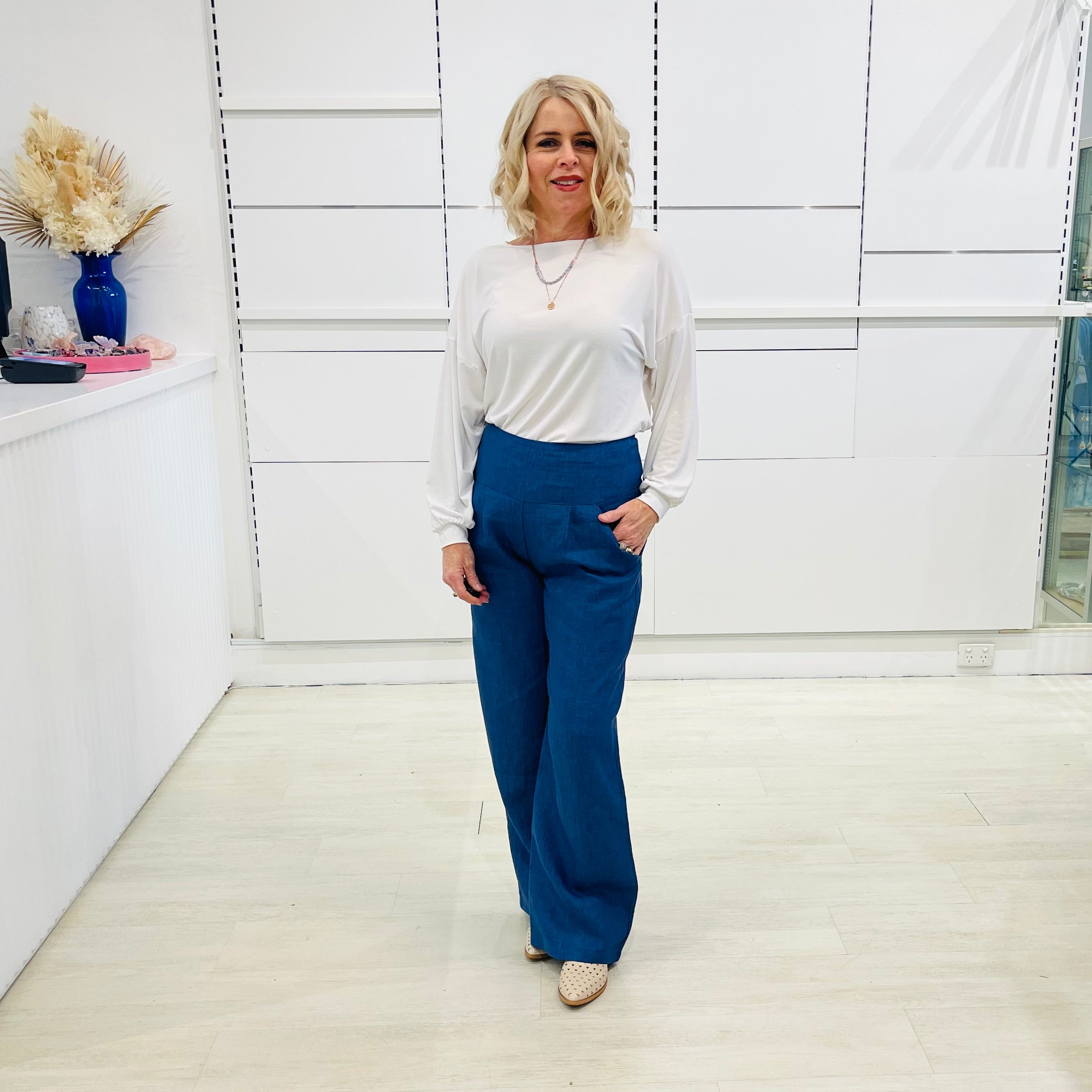 Denim blue,wide leg linen pants with flat waistband, zipper opening and pockets,worn with white bamboo, relaxed fit, long sleeve Gracie top.