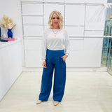 Denim blue,wide leg linen pants with flat waistband, zipper opening and pockets,worn with white bamboo, relaxed fit, long sleeve Gracie top.