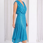 Model in white room wearing blue dress