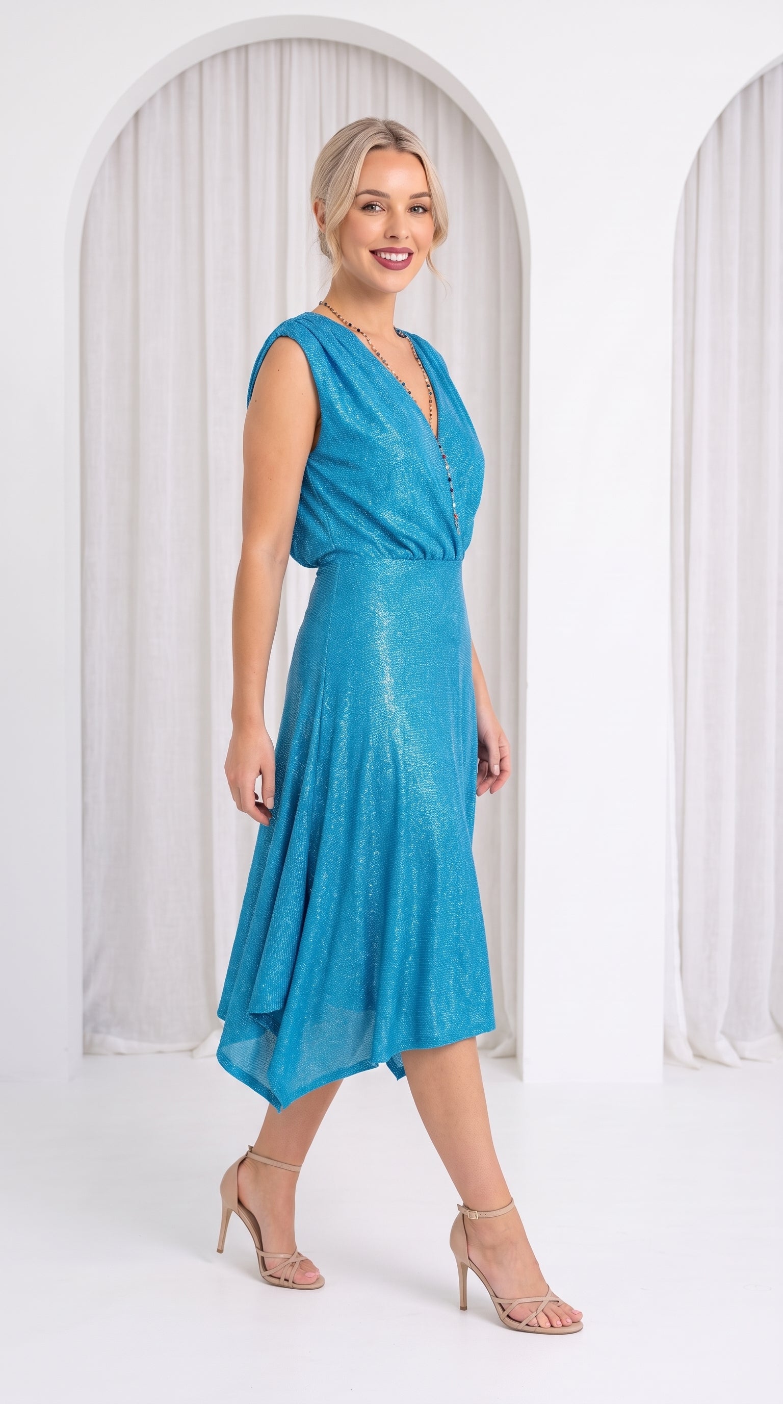 Model in white room wearing blue dress