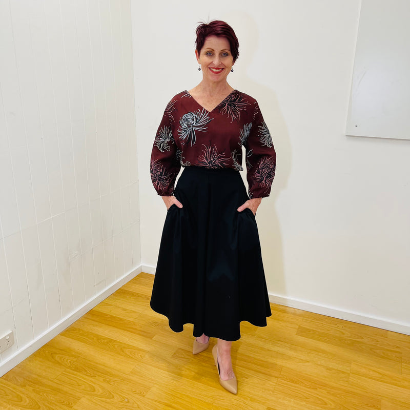 Gored paneled flared skirt in
Black sateen 7/8 length with pockets a fitted waistband and a centre back zipper True Reflections Clothing Gymea 
